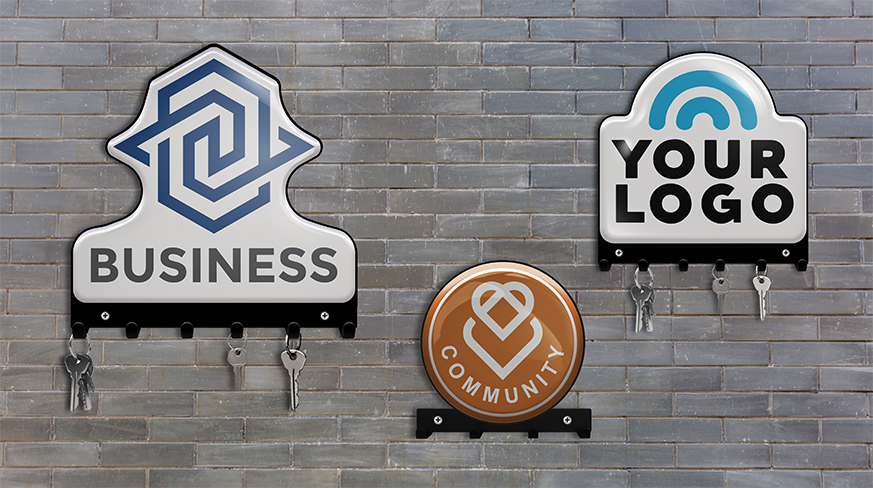 Kolme avainlautaa tiiliseinässä: BUSINESS sinisellä logolla, YOUR LOGO kaaren kanssa, COMMUNITY sydämen kanssa, avaimet kiinni