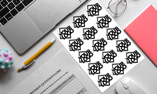 Työtila, jossa on kannettava tietokone, kynä, muistivihko ja 