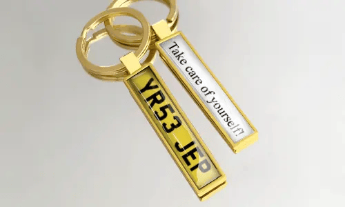 Gullfargede metallnøkkelringer med nummerskilt har personlige design og gravert tekst