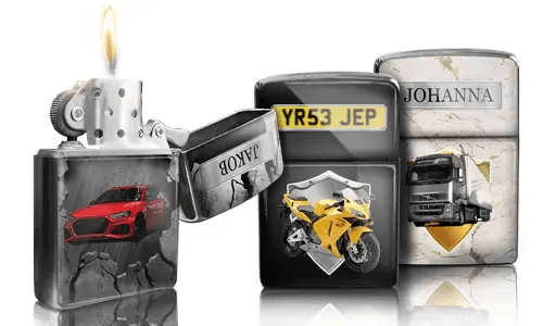 Drei metallische Feuerzeuge mit individuellen Designs: ein rotes Auto, ein gelbes Motorrad mit Kennzeichen und ein LKW mit der Aufschrift „JOHANNA“. Ein Feuerzeug ist geöffnet und die Flamme brennt.