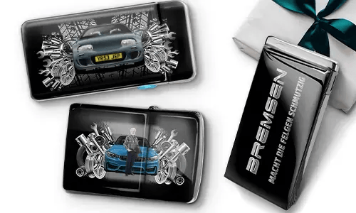 Drei Auto-Themen-Artikel mit Auto-Illustrationen und Maschinen-Motiven, arrangiert neben einer Geschenkbox, die mit einer grünen Schleife gebunden ist.