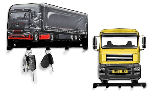 Zwei schlüsselförmige Halter in LKW-Form: schwarz-roter Sattelschlepper mit Anhänger und drei Haken, gelber LKW mit vier Haken