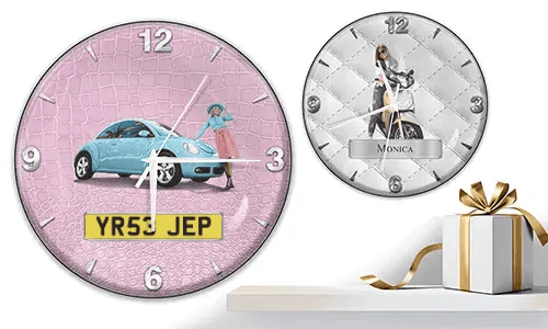 Two wall clocks with female figures and vehicles: left with black car on purple waves, right with red and black cars, racing flags, and blue background