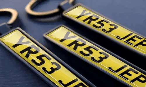 I portachiavi targhe personalizzati mostrano numeri incisi e testo su misura in cornici metalliche