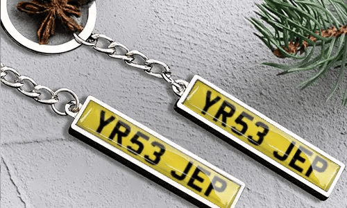 Metallinen avaimenperä, jossa rekisterikilpi ja lippudetalji