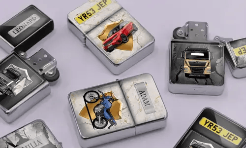 A variety of metal lighters lie on a soft purple surface, featuring personalized designs of cars, motorcycles, and trucks, each marked with different names.