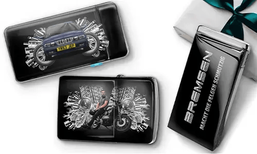 Elegante Geschenkboxen mit einem blauen Auto und einem Biker, umgeben von metallischen Zahnrädern. Eine Box trägt den Text „BREMSEN Macht Die Regeln Schmutzig“, was einen dynamischen, kantigen Ton hinzufügt.