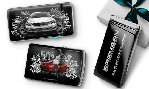 Three sleek black wallets with images of cars and gears, placed near a gift box. 