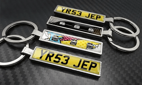 Set aus Comic-Kennzeichen-Schlüsselanhängern mit bunten Autodesigns und Metallfinish