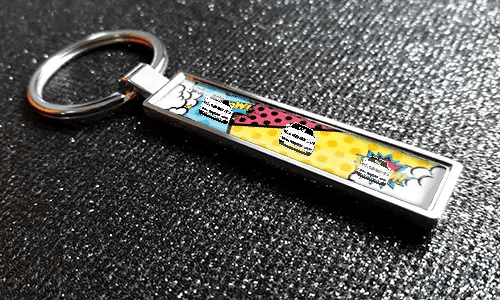 Metal comic car keychain with pop art design and colorful vehicle illustration