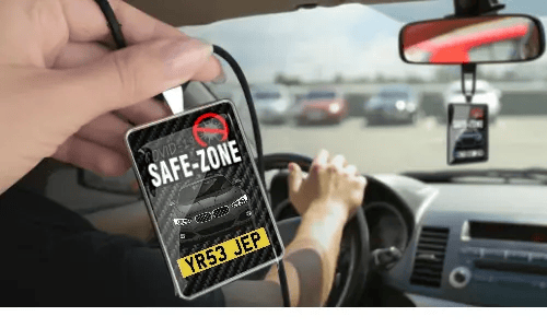 Auto-Safezone-Anhänger mit Carbon Hintergrund in der Hand Auto-Schutzraum-Anhänger