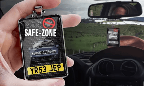 Auto-Safezone-Anhänger mit Carbon Hintergrund und Metallkette in der Hand Safezone-Anhänger