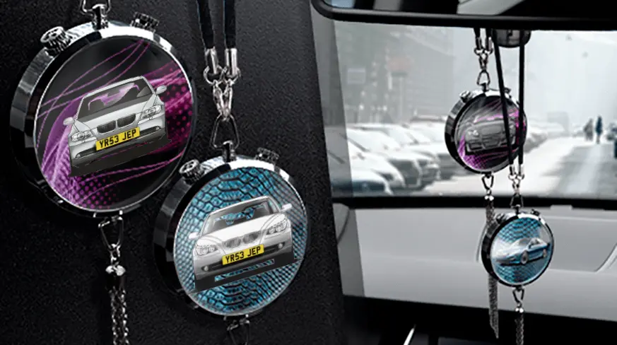 Two circular car air fresheners hanging from rearview mirror: left with black car, right with blue car