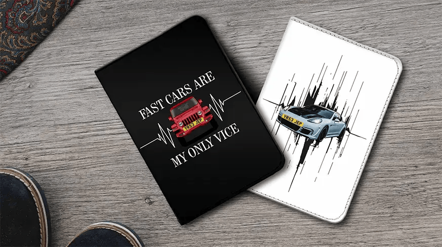 Dos fundas para notas de coche en superficie de madera: Izquierda negra con coche rojo y cita FAST CARS, derecha blanca con coche deportivo azul y líneas de movimiento